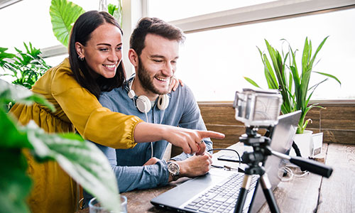 Two people working on a project using a laptop and a GoPro.