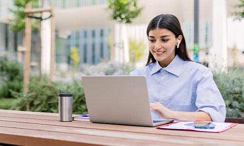 Student working on their laptop outdoors.